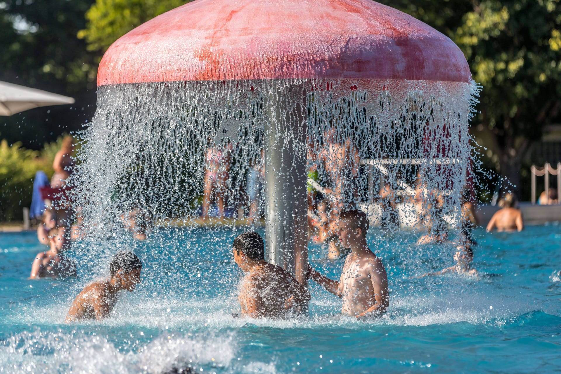 Menschen kühlen sich unter einem Wasserpilz ab (Symbolbild): In Mammendorf bleibt das Freibad am Mittwoch geschlossen.