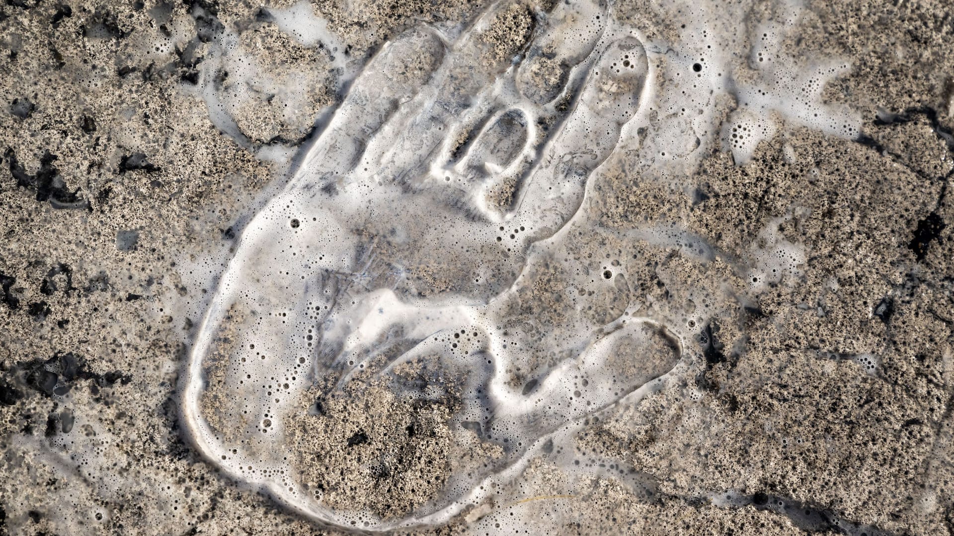 Ein Handabdruck auf dem Asphalt am Münchner Stachus: Seit Anfang 2022 ist Sekundenkleber die Waffe der Wahl für die "Letzte Generation" und hat den Klimaklebern ihren Namen eingebracht.