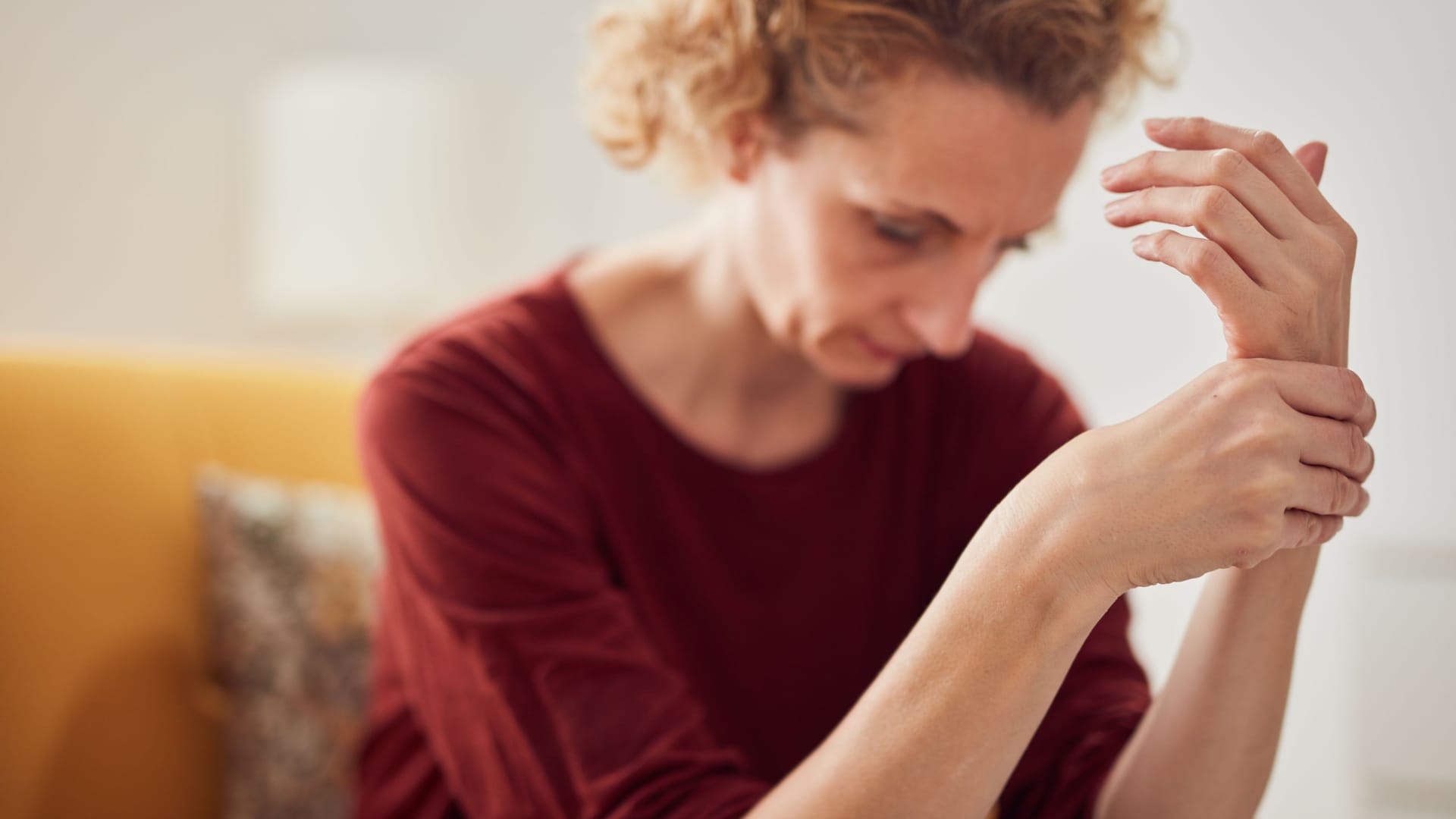 Frau mit Fingerschmerzen: Eine Heberden-Arthrose kann mit Schmerzen in den Fingern einhergehen.