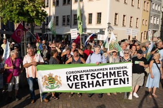 Teilnehmer einer Kundgebung der rechtsextremen Kleinstpartei Freie Sachsen stehen anlässlich einer CDU-Wahlkampfveranstaltung auf dem Marktplatz und tragen ein Transparent mit der Aufschrift "Kretschmer verhaften".