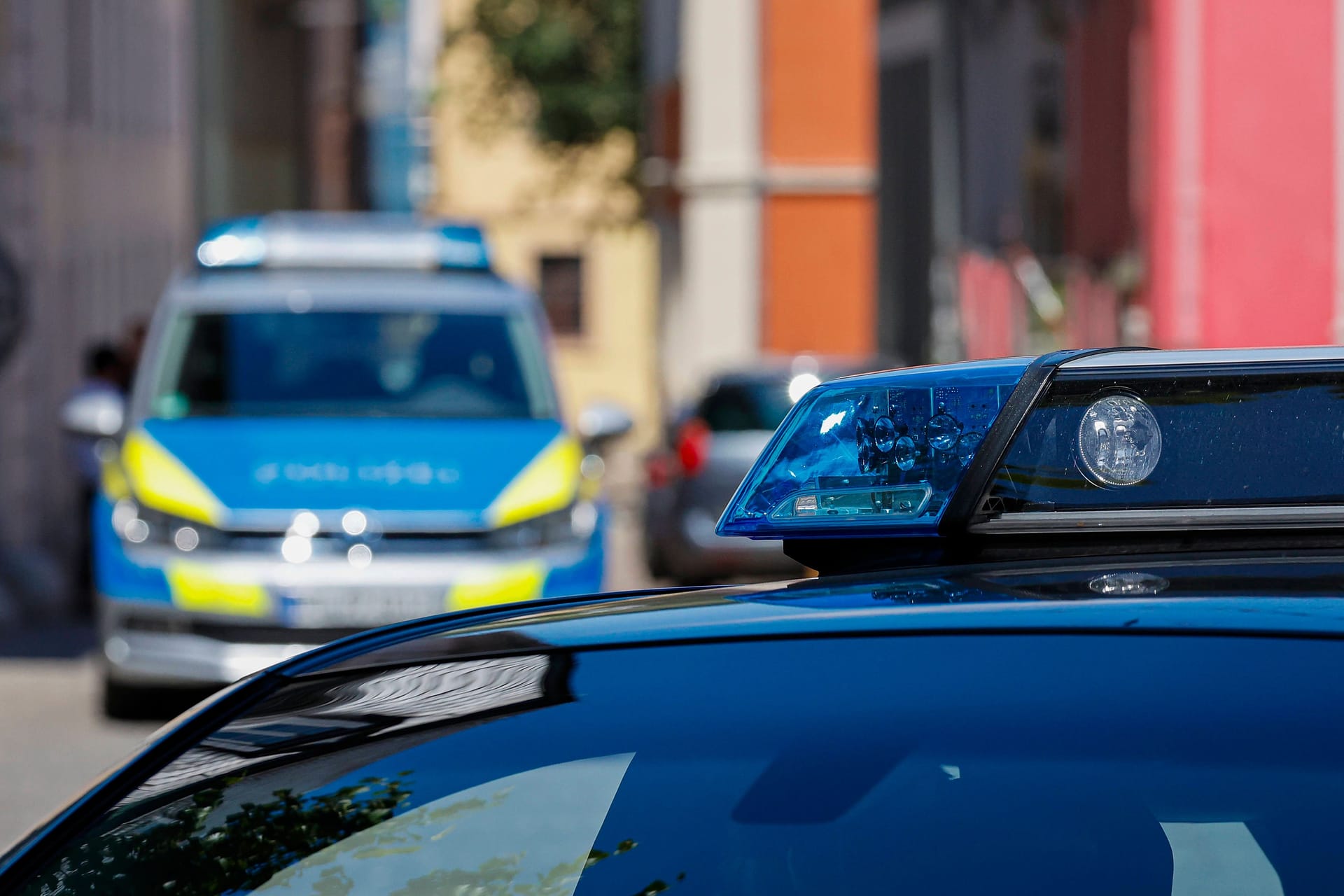 Zwei Polizeiautos stehen in einer Straße: In Bayenthal kam es in einer Asylunterkunft zu einer Messerattacke.