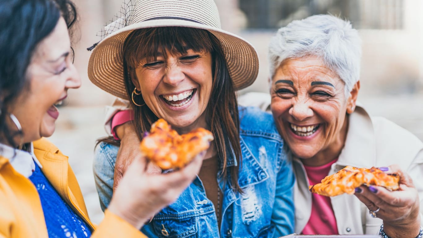 Drei Frauen teilen sich eine Pizza: An gutes Essen ist in Italien leicht zu kommen.