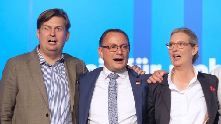 Sichtlich zufrieden: Spitzenkandidaten Krah, Parteichefs Chrupalla und Weidel bei der Nationalhymne am Ende des Parteitags.