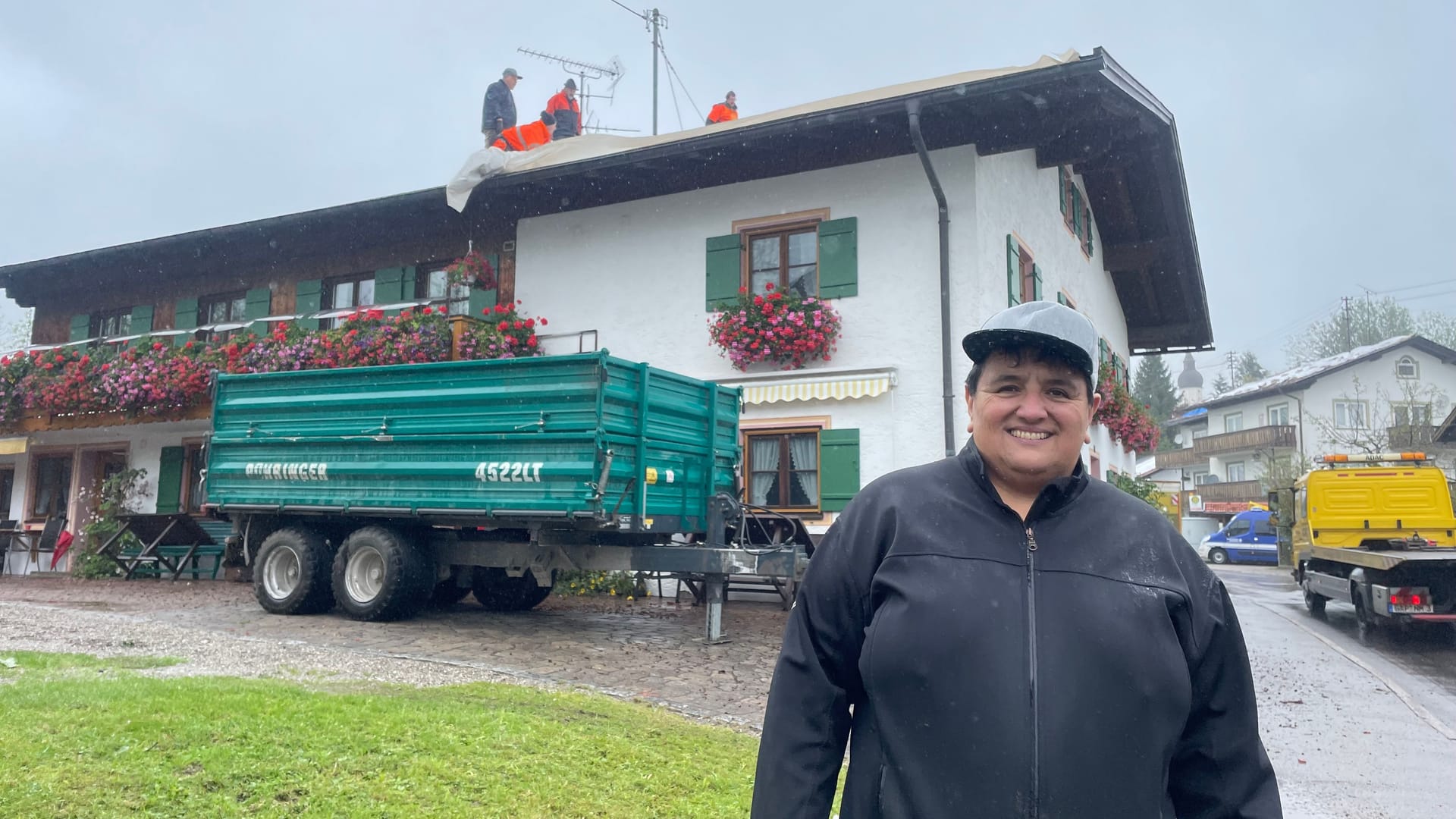 "Gemeinsam schaffen wir alles", gibt sich Birgit Klöck trotz der Zerstörung ihres Hauses zuversichtlich. Im Hintergrund befestigen freiwillige Helfer eine Plane über den kaputten Ziegeln.