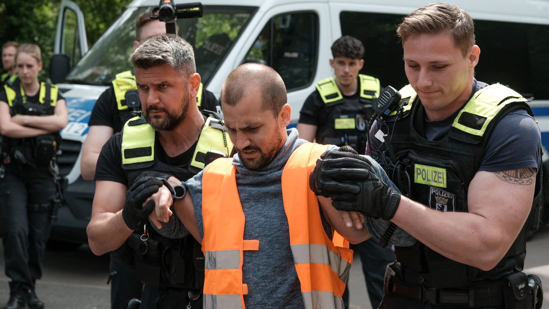 Ein Aktivist wird abgeführt (Archivbild): In Berlin sucht die Polizei öffentlich nach drei Klimaklebern.