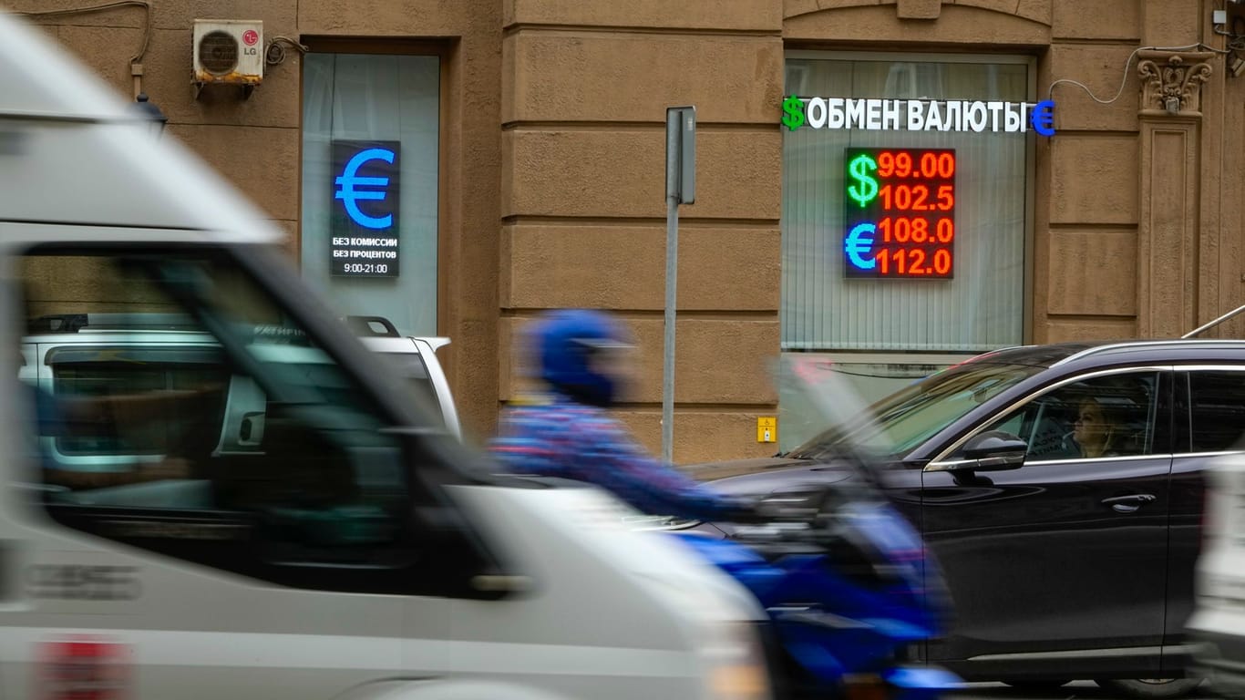 Fahrzeuge fahren an einer Wechselstube vorbei (Archivbild): Der russische Rubel liegt nun bereits unter 99 Dollar.