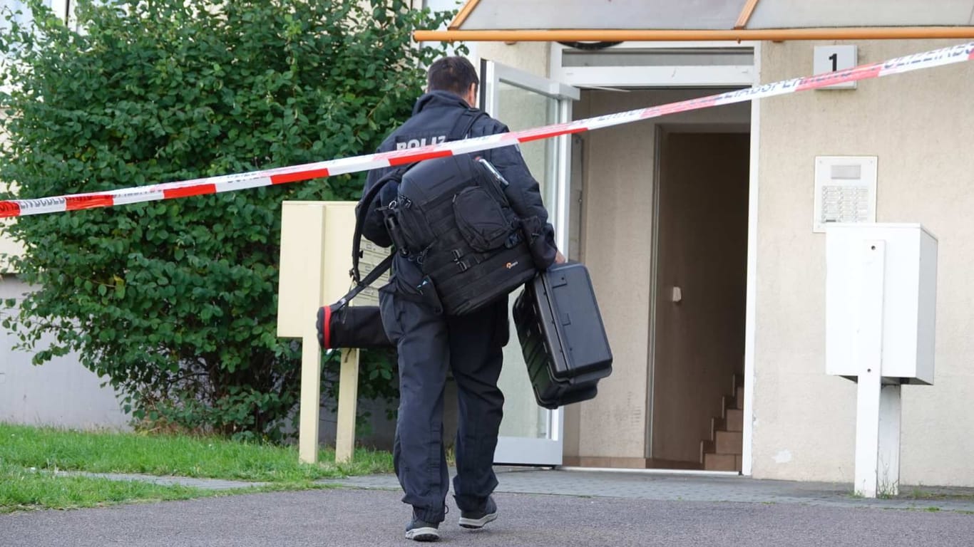 Ein Polizeibeamter vor einem Mehrfamilienhaus in Dresden: Einsatzkräfte fanden am Donnerstagnachmittag dort einen schwerverletzten Mann vor.