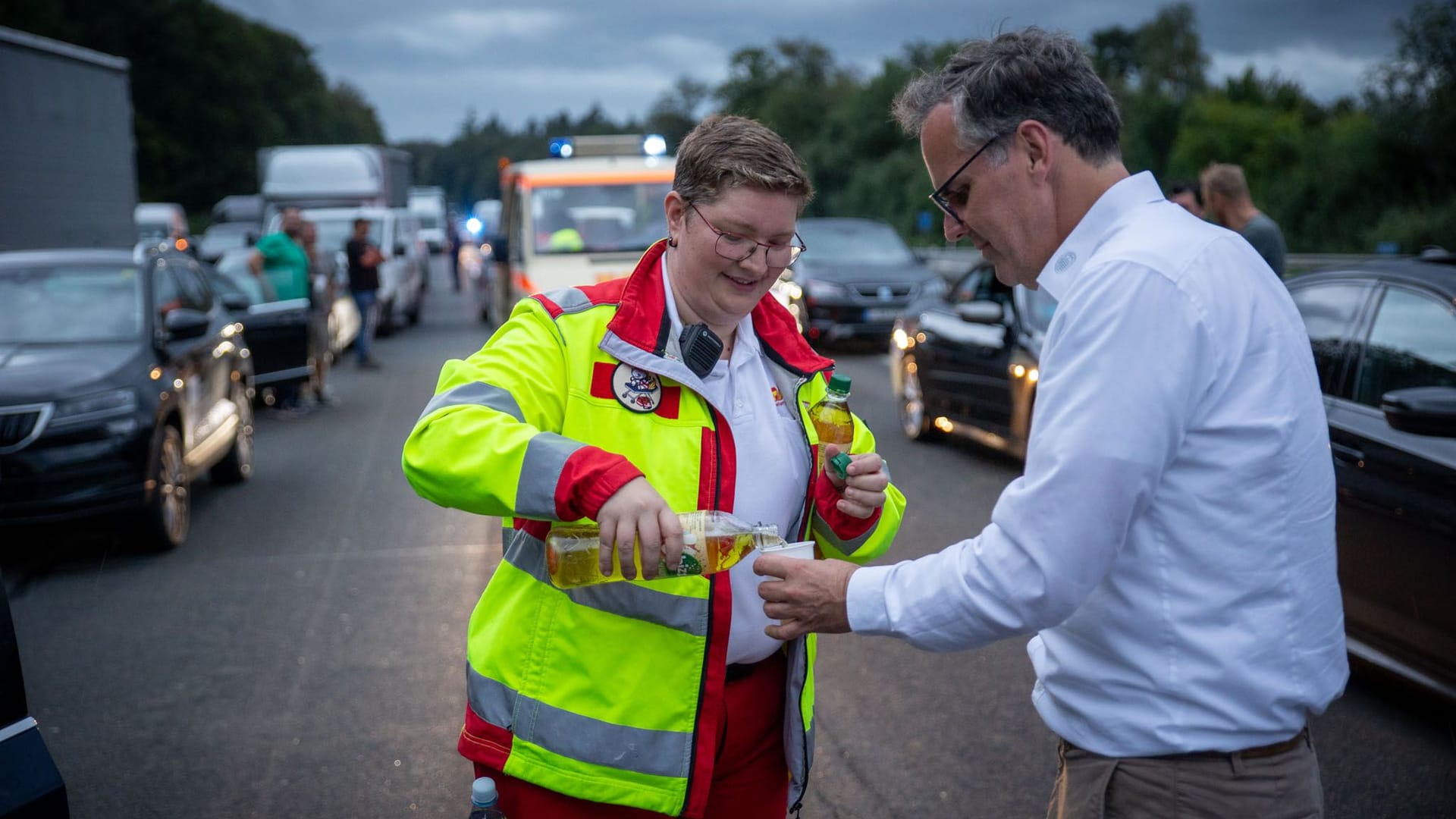 Ehrenamtliche Rettungskräfte verteilen Getränke auf der A3.