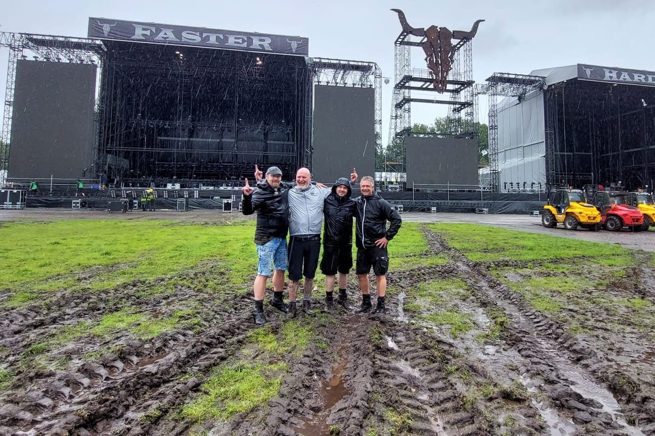 Früh angereiste Metalfans stehen vor der Wacken-Bühne im Matsch: Hier soll ab Mittwoch gerockt werden.