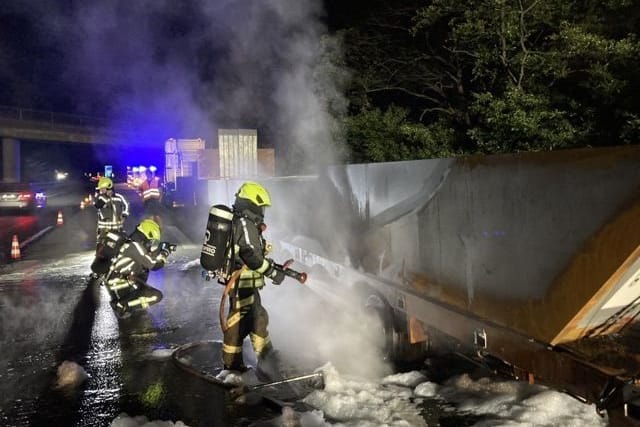 Löscharbeiten an dem Auflieger: Bis das Hindernis von der Autobahn gebracht werden kann, dauert es laut Polizei "noch geraume Zeit".