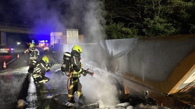 Löscharbeiten an dem Auflieger: Bis das Hindernis von der Autobahn gebracht werden kann, dauert es laut Polizei "noch geraume Zeit".