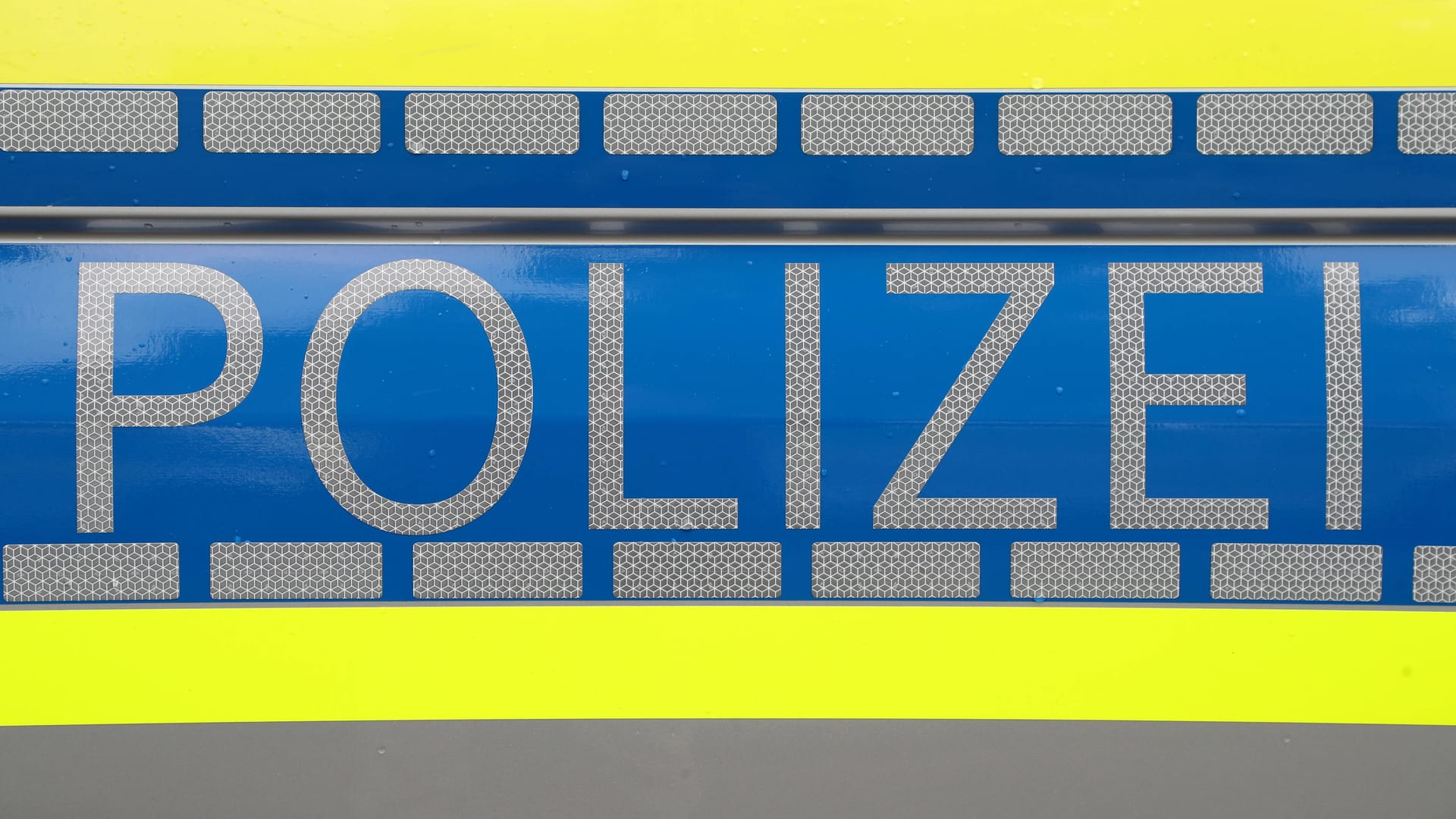 Der Schriftzug "Polizei" auf der Tür eines Streifenwagens