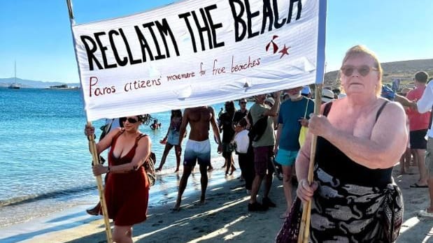 Aktivisten der Bewegung "Save Paros Beaches" demonstrieren an einem Strand von Paros (Griechenland) gegen die "Besatzung" durch illegale Sonnenbettfirmen. Sie argumentieren, die Strände seien ein öffentlicher Raum und auch Einheimische müssten genug Platz finden.