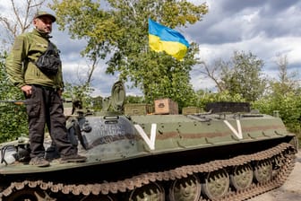 Ein ukrainischer Soldat steht auf einem eroberten russischen Panzer (Archivbild).