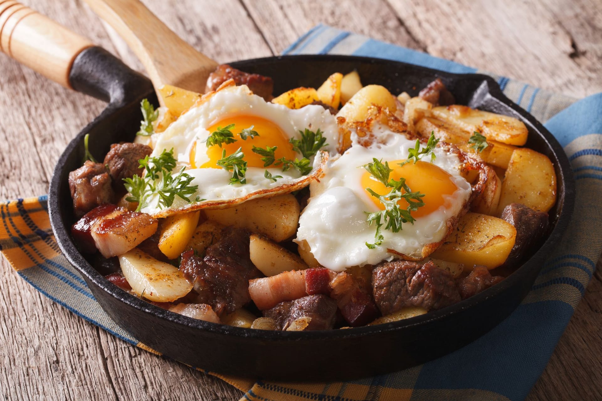 Klassische Bratkartoffeln mit Spiegeleiern und Speck.