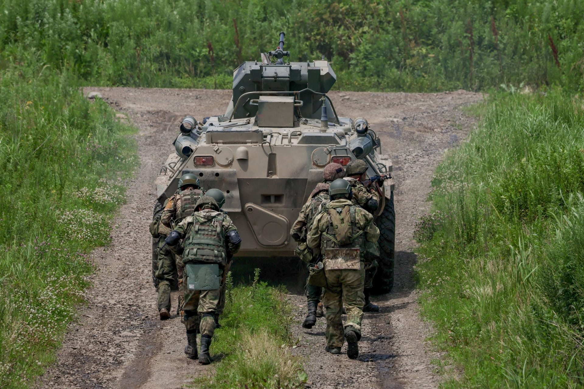 Soldaten laufen hinter einem russischen BMP-3-Schützenpanzer. Auf einem Video waren jetzt kuriose Schutzmaßnahmen zu sehen.