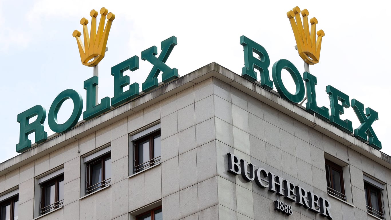 Logos von Rolex und Bucherer: Der Luxusuhrenhersteller möchte den Uhren- und Schmuckhändler Bucherer übernehmen.