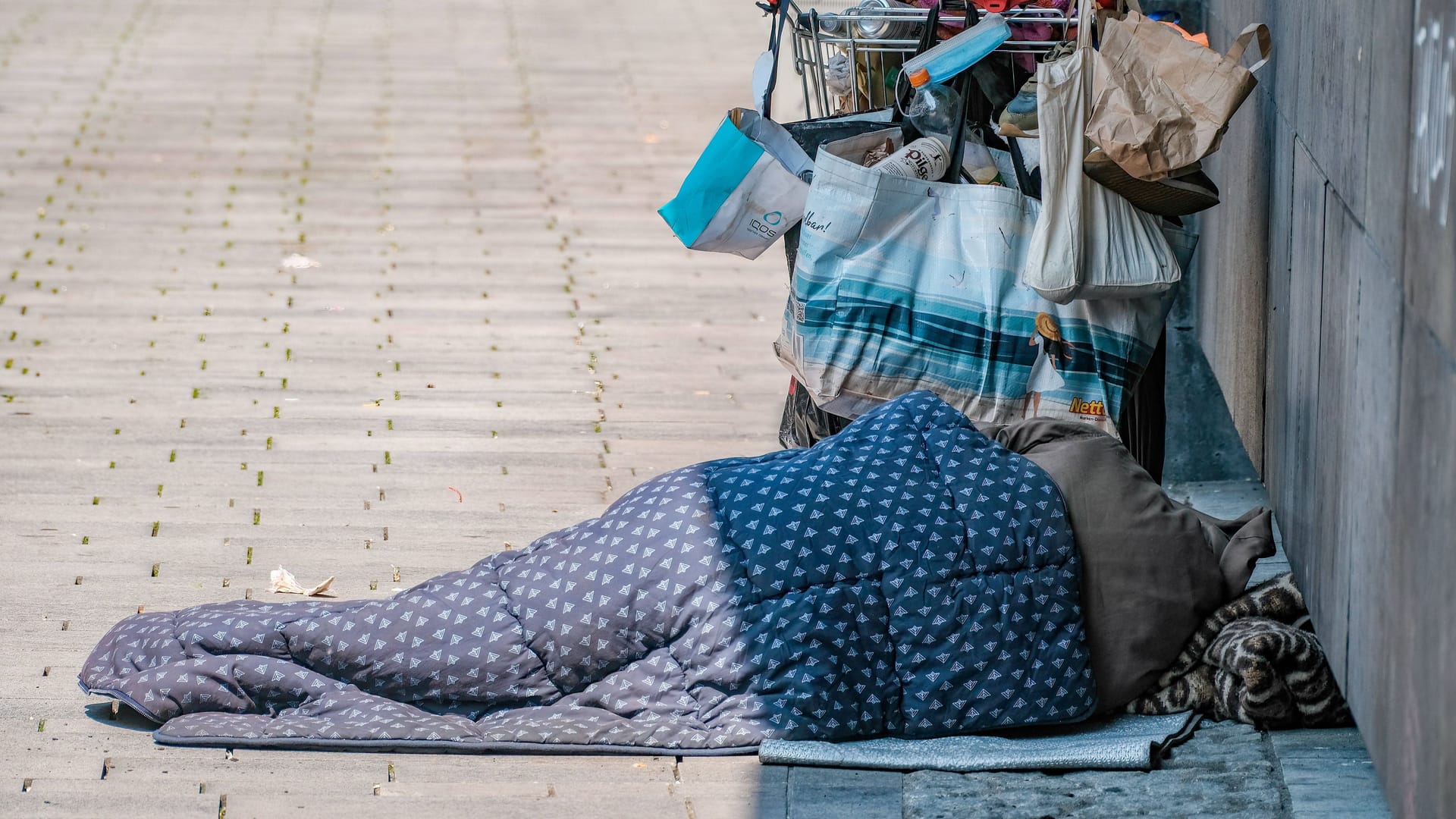 Auf den Straßen von Düsseldorf: Ein Obdachloser schläft neben seinem Einkaufswagen. Auf den Straßen von Düsseldorf: Ein Obdachloser schläft neben seinem Einkaufswagen.