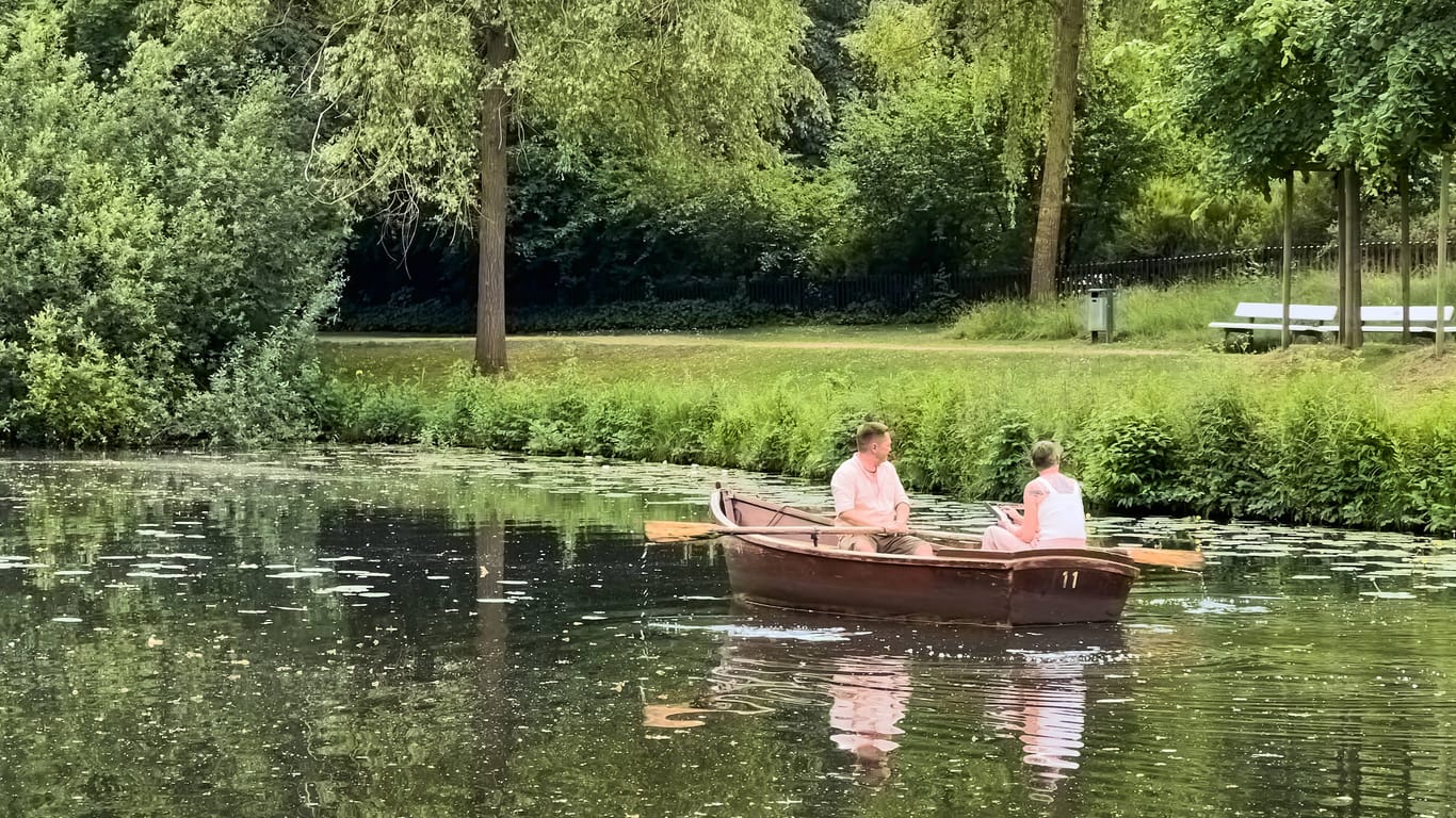 Zwei Menschen sitzen in einem Ruderboot im Bürgerpark Bremen: Nächste Woche wird es richtig warm.