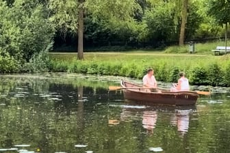 Zwei Menschen sitzen in einem Ruderboot im Bürgerpark Bremen: Nächste Woche wird es richtig warm.