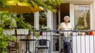 Rentnerin auf ihrem Balkon (Symbolbild): Im Alter kann schon mal ein Umzug anstehen. Hat der Verkauf der Wohnung dann Folgen für die Witwenrente?