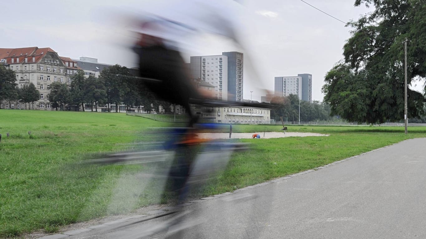 Ein Radfahrer fährt auf dem Elberadweg unterhalb von Dresden-Johannstadt.