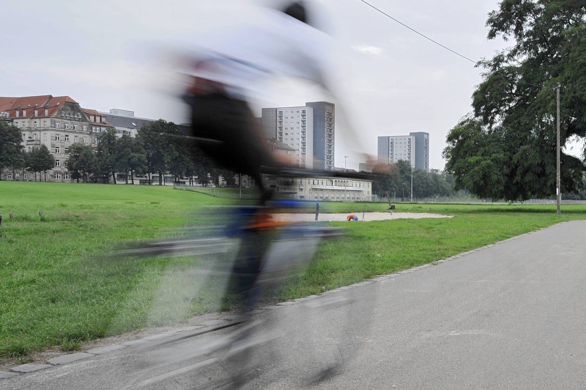 Ein Radfahrer fährt auf dem Elberadweg unterhalb von Dresden-Johannstadt.