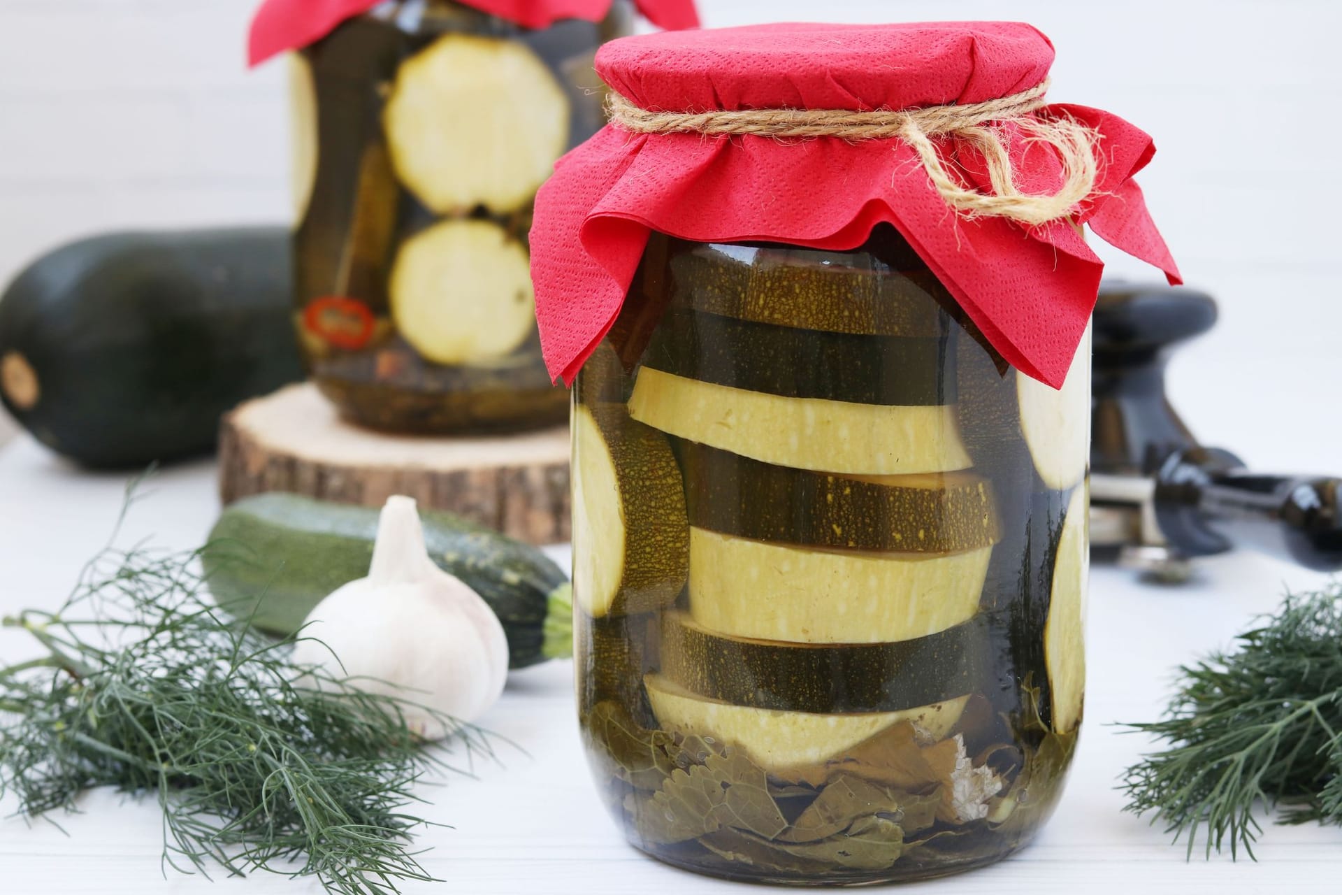 Die in Scheiben geschnittenen Zucchini werden in einem Einmachglas geschichtet.