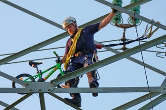 Ein mehrfach gesicherter Experte holt das Rad vom Strommast: Wer es dort angebracht hat, ist noch unklar.