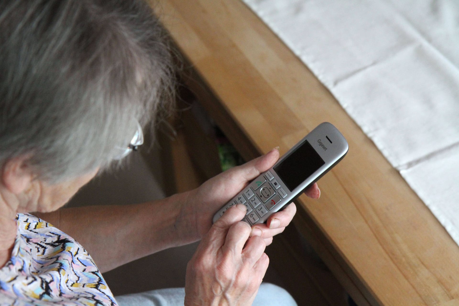 Ältere Frau mit einem Telefon (Symbolbild):