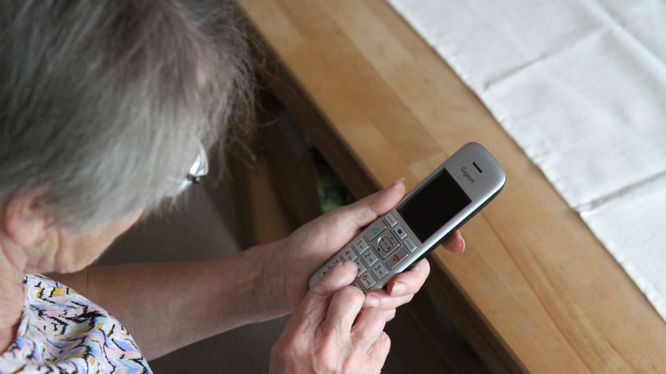 Ältere Frau mit einem Telefon (Symbolbild):