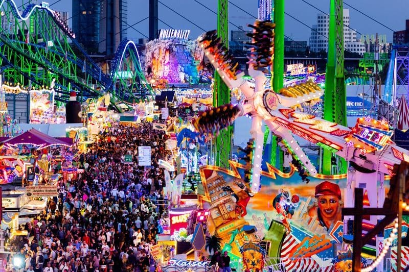 Besucher gehen über die Düsseldorfer Rheinkirmes (Archiv): An zehn Kirmestagen werden mehrere Millionen Besucherinnen und Besucher erwartet.