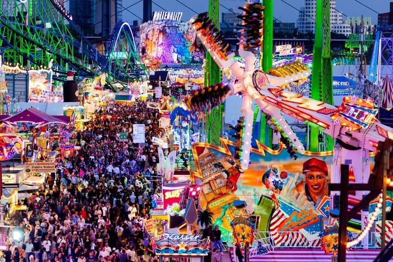 Besucher gehen über die Düsseldorfer Rheinkirmes (Archiv): An zehn Kirmestagen werden mehrere Millionen Besucherinnen und Besucher erwartet.