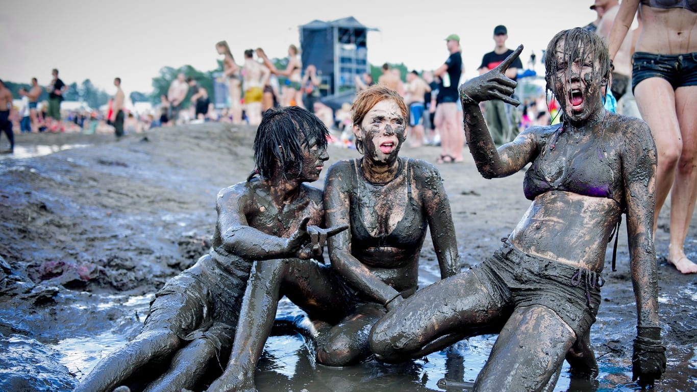 Drei Frauen sitzen bei einem Festival im Schlamm (Symbolbild): Make-up ist hier unnötig.