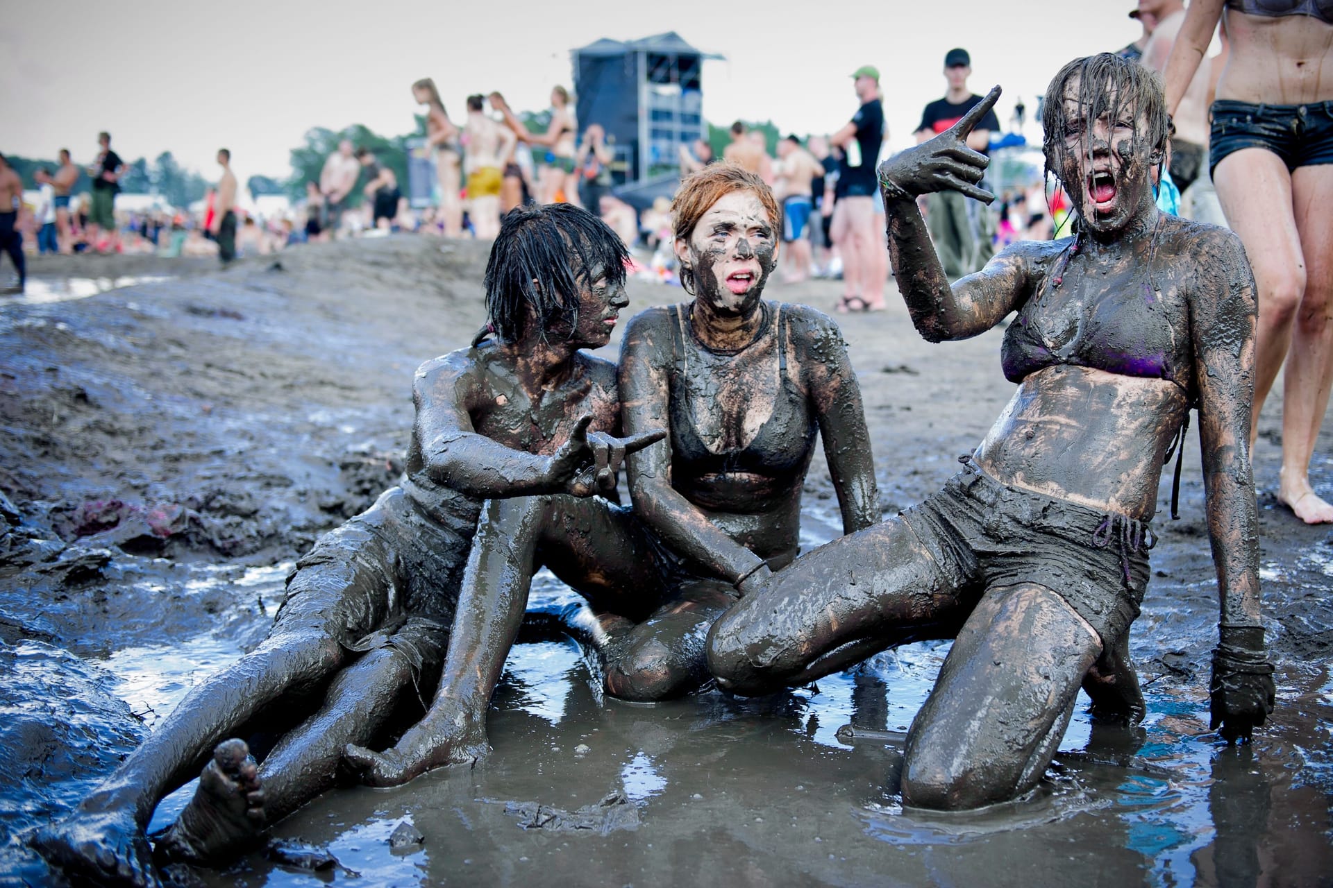 Drei Frauen sitzen bei einem Festival im Schlamm (Symbolbild): Make-up ist hier unnötig.