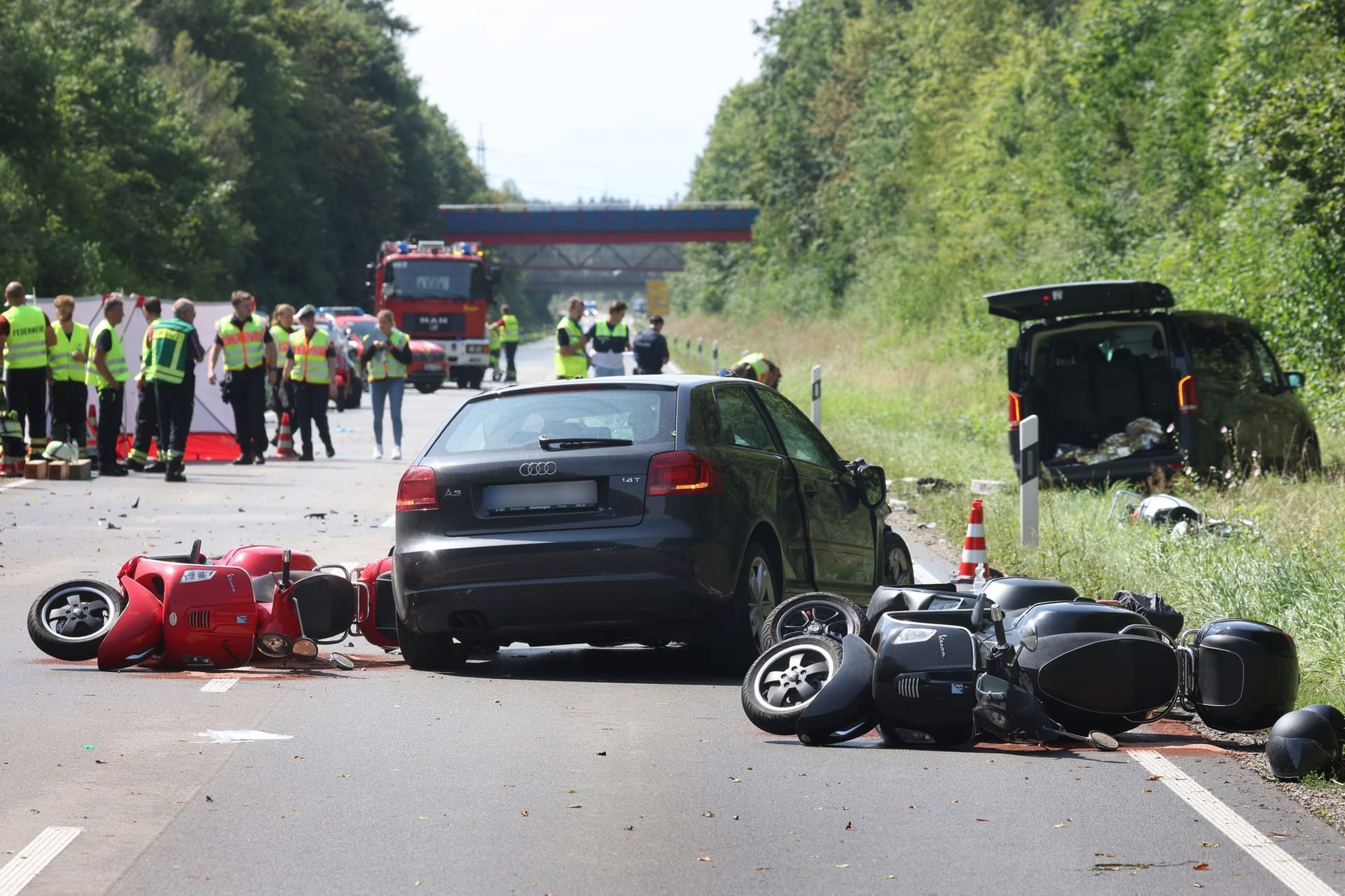 Beschädigte Motorroller liegen auf der Bundesstraße 17 um ein zerstörtes Auto: Bei dem Unfall sind laut Polizei mehrere Menschen teils schwerst verletzt worden.