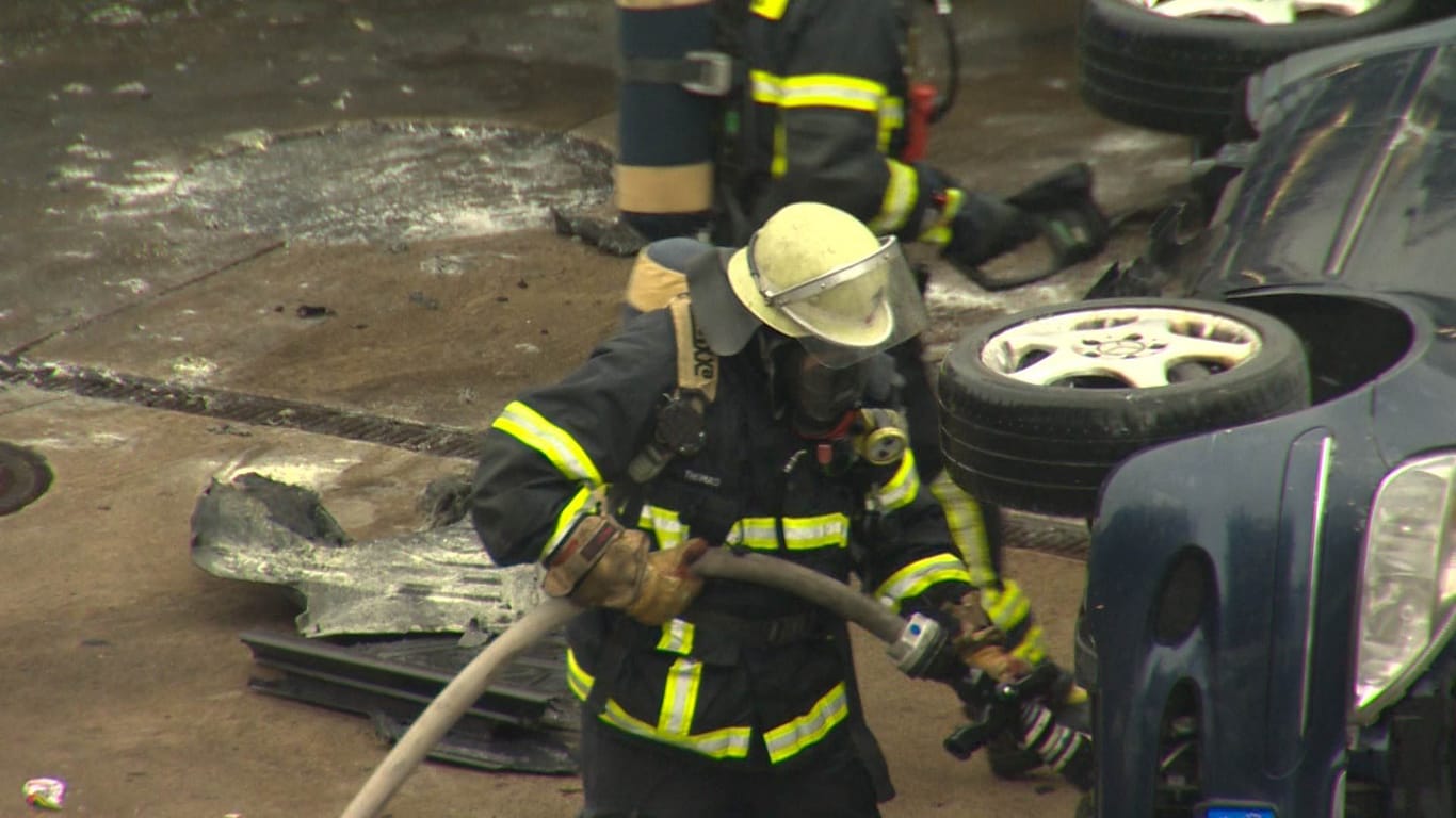 Ein Feuerwehrmann beim Löschen des Mercedes.