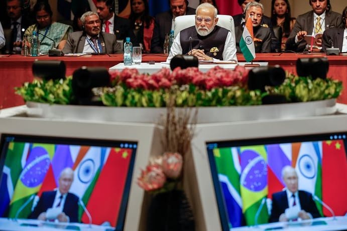 Indiens Premierminister Narendra Modi (M) schaut der Plenarsitzung auf dem Brics-Gipfel 2023 zu, während Kremlchef Wladimir Putin per Videoübertragung spricht.