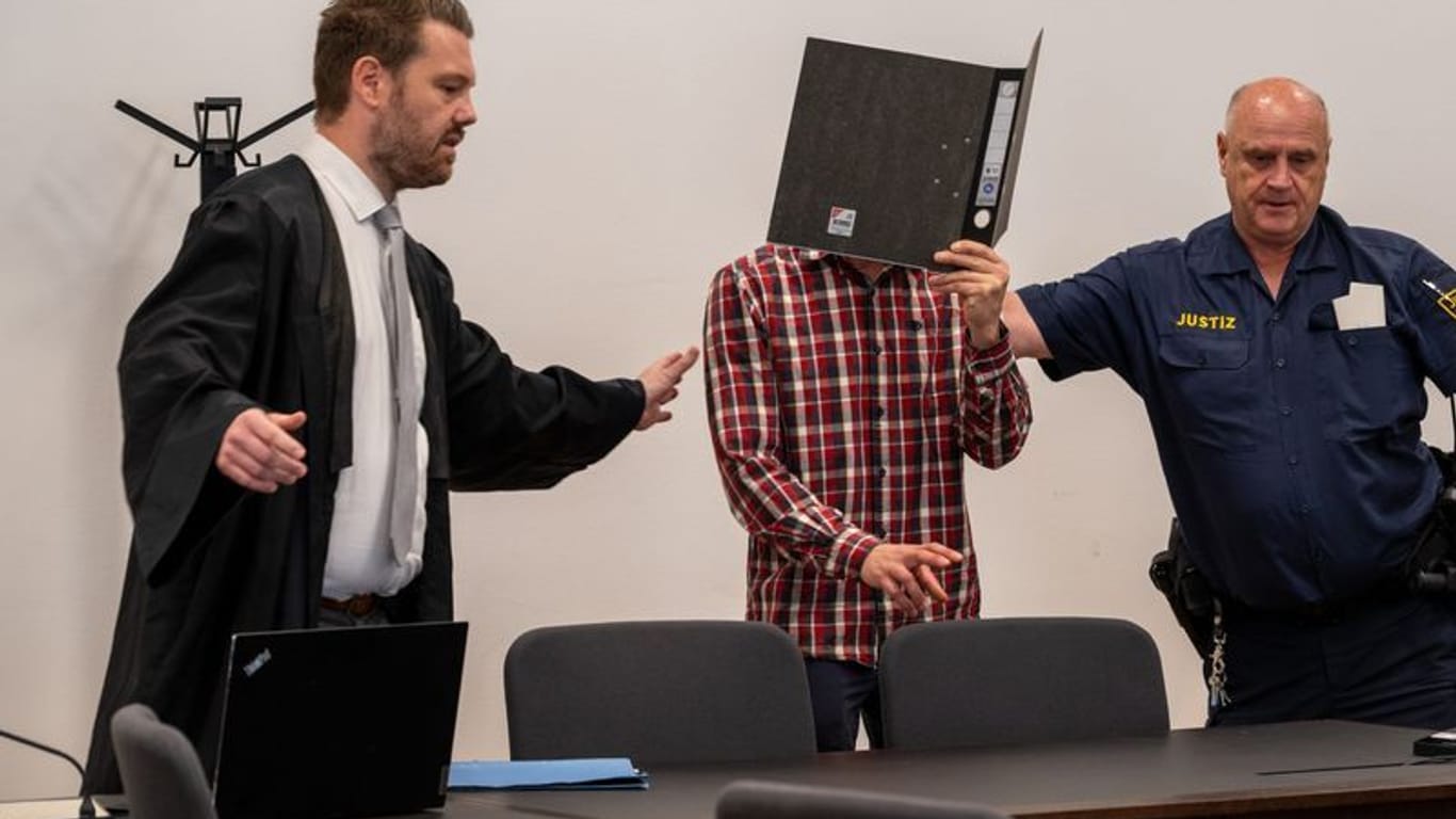 Heute ist das Urteil gegen einen 43-Jährigen gefallen: Der Angeklagte wird von einem Justizbeamten und seinem Rechtsverteidiger zu seinem Sitzplatz im Strafjustizzentrums Nürnberg gewiesen.