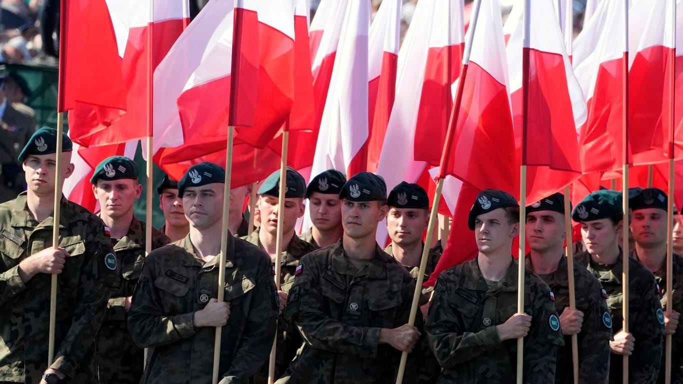 Militärparade in Warschau: Soldaten tragen polnische Nationalfahnen.