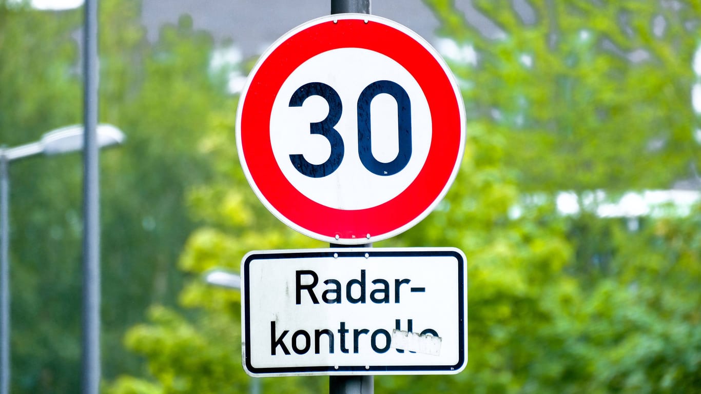 Tempo 30: Verkehrsschild mit Warnung vor Geschwindigkeitskontrolle