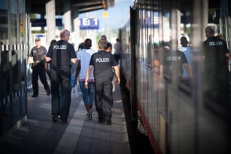 Polizisten bei einer Kontrolle am Zug (Symbolbild): In Bayern haben zwei Verdächtige nun gleich mehrere Probleme auf einmal.