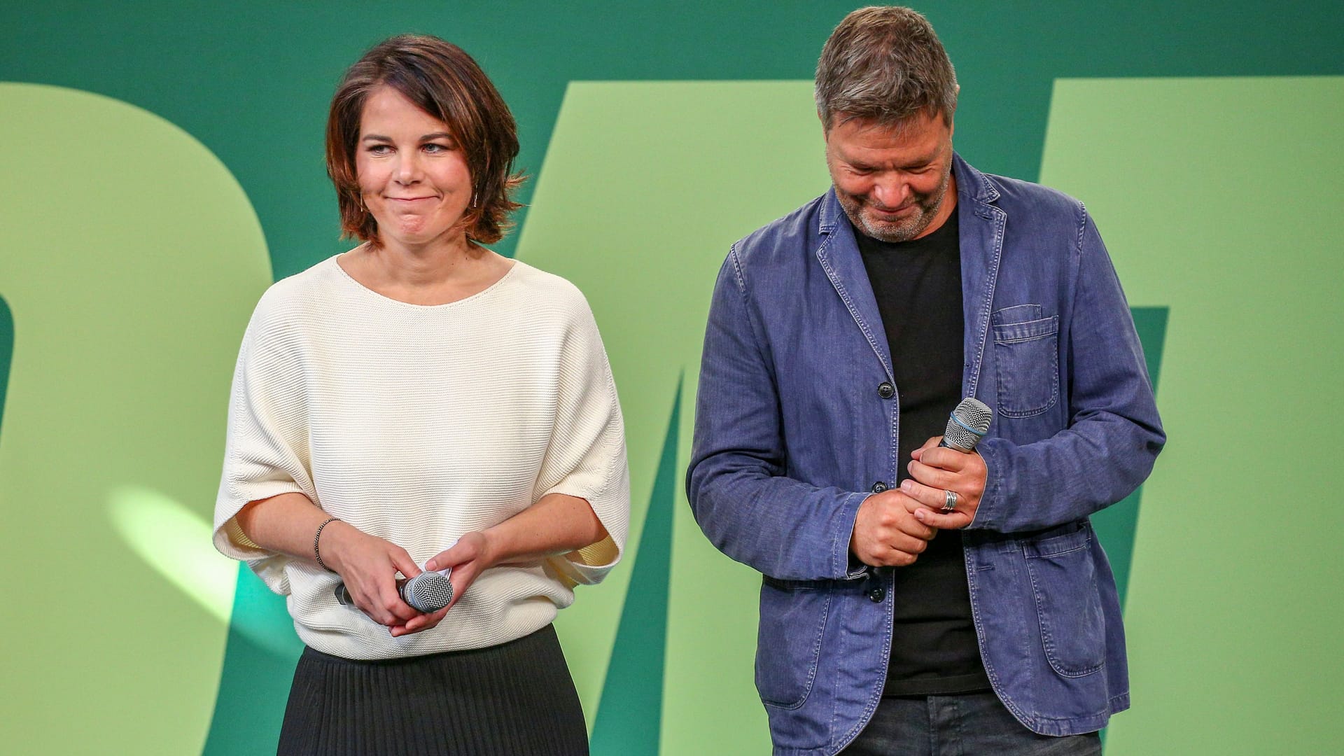 Annalena Baerbock (l.) und Robert Habeck (r.) bei einer Veranstaltung der Grünen: Die beiden Politiker werden auf dem Plakat angefeindet.