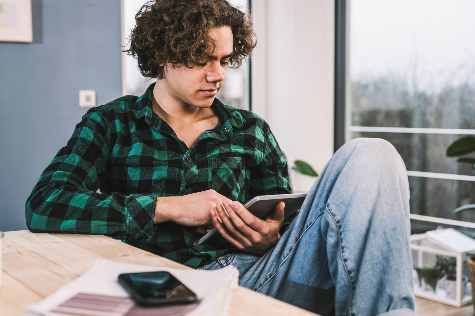 Junger Mann am Tablet (Symbolbild): Junge Menschen sind eher unzufrieden, als ältere Menschen in Deutschland.