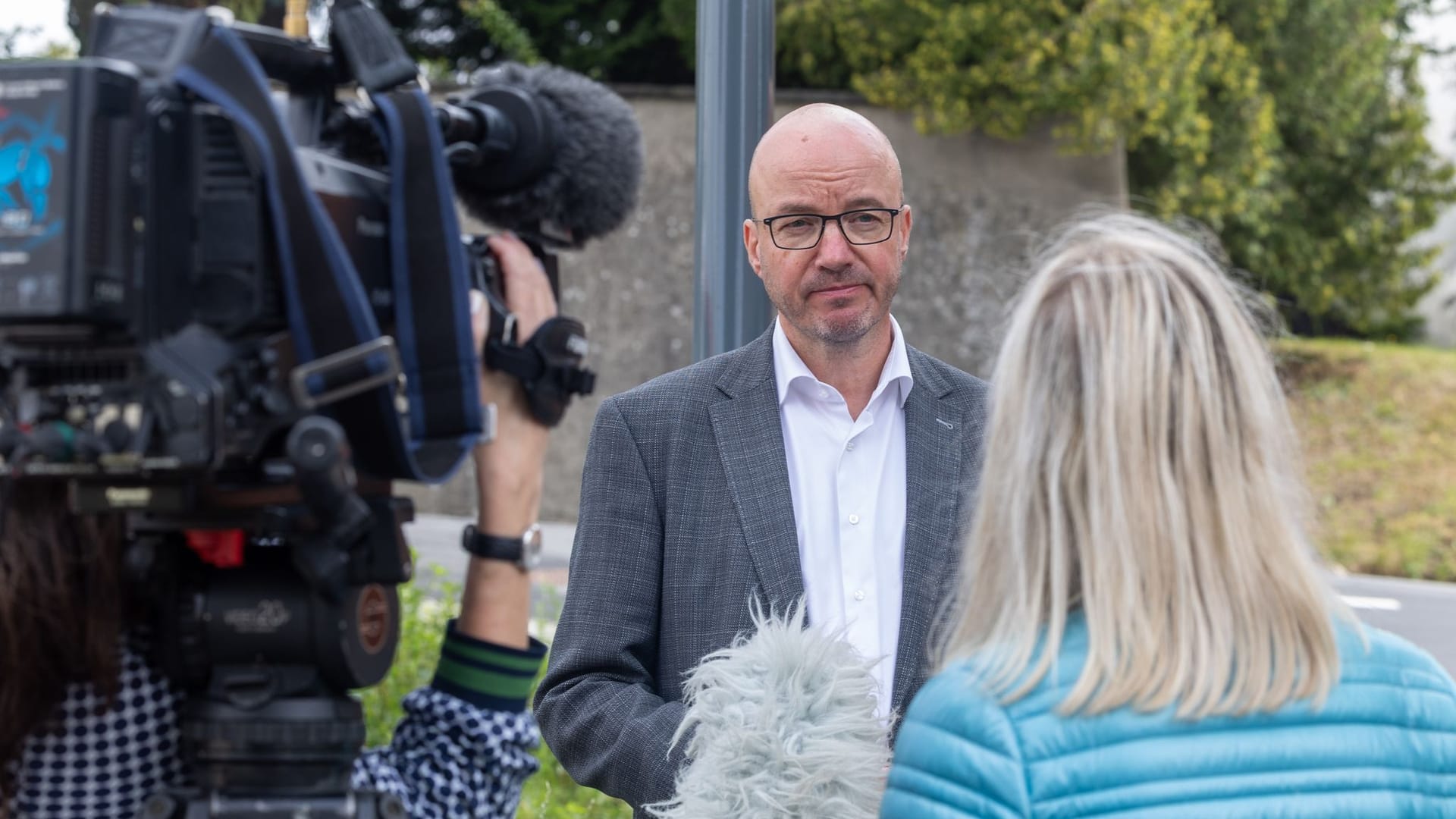 Evangelischer Landesbischof Sachsen Christian Tobias Bilz (M) gibt bei seinem Besuch an der abgebrannten Stadtkirche Großröhrsdorf ein Interview.