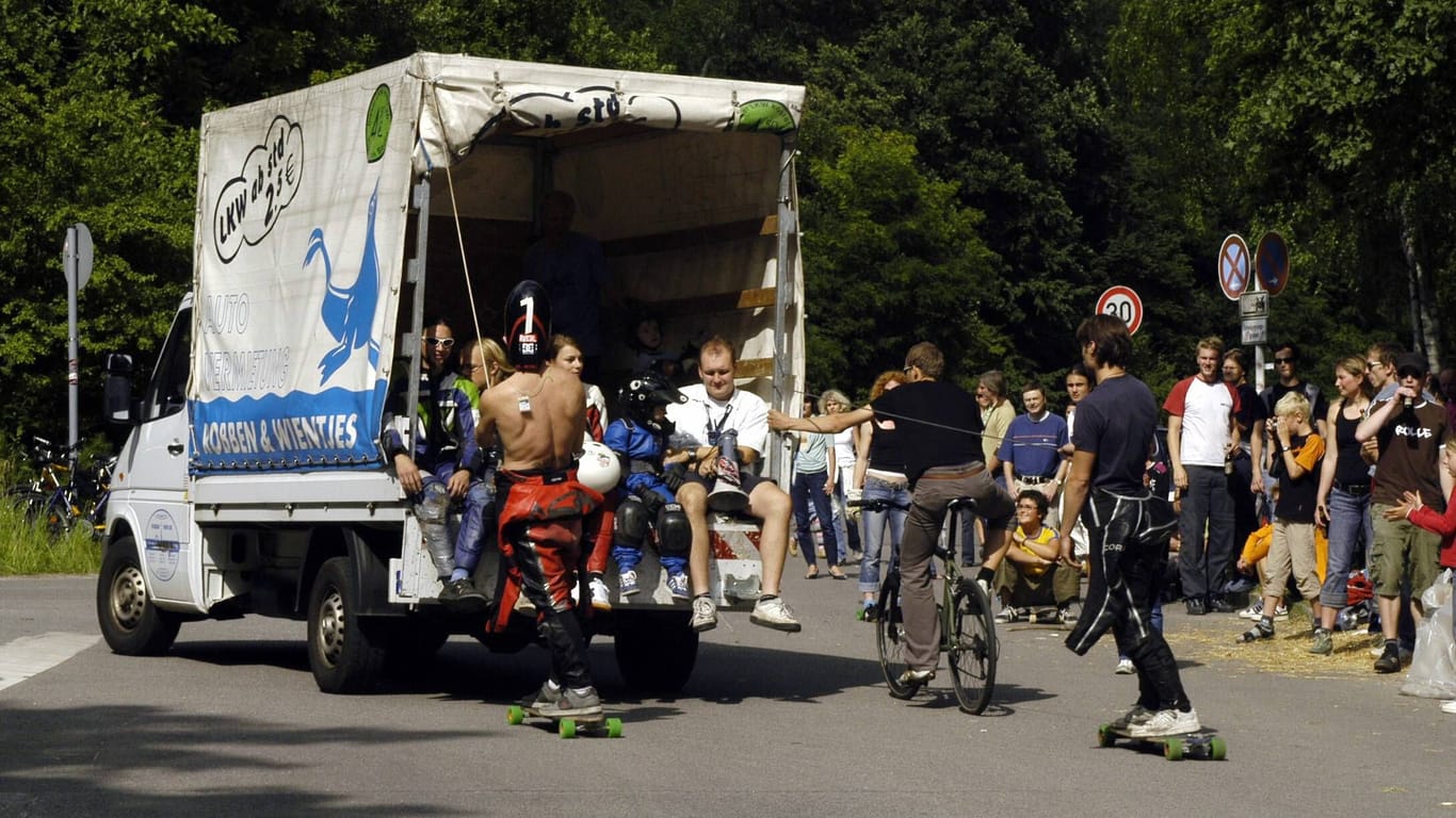 Ein Longboarder und ein Radfahrer lassen sich von einer "Robbe" ziehen (Archivbild, 2005): Die Fahrzeuge prägten jahrzehntelang das Berliner Stadtbild.