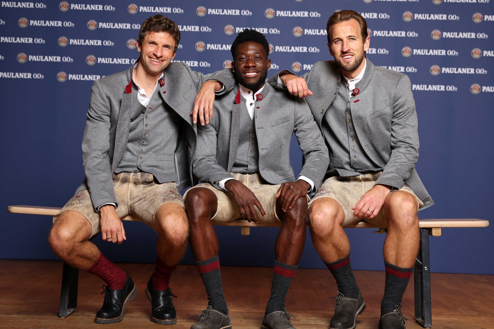 Thomas Müller, Alphonso Davies und Harry Kane (von links) in Lederhose: Bayern-Fans mussten auf die Bilder des Engländers etwas warten.