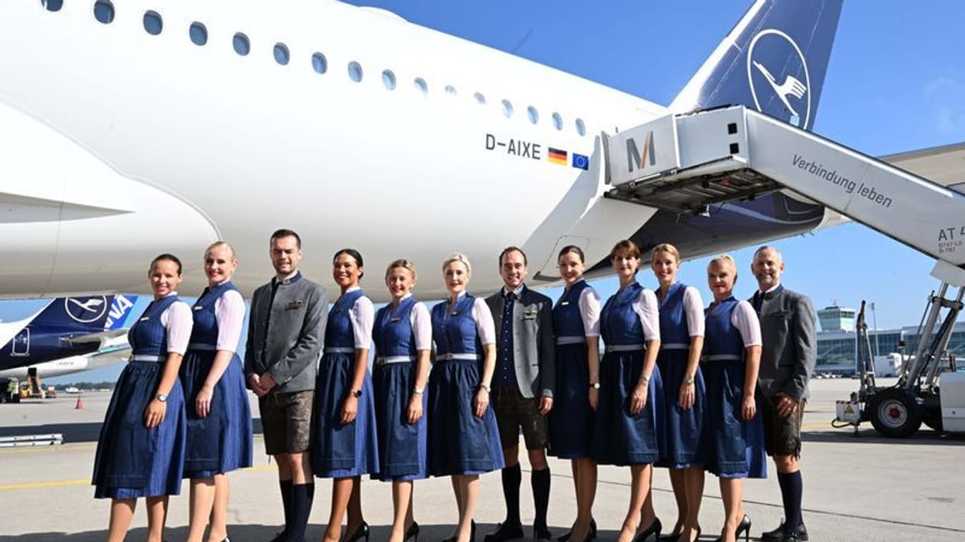 Die Lufthansa-Trachtencrew 2023 steht auf dem Rollfeld des Flughafen München: Für sie geht es nach Mexiko City.