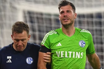 Ganz schwerer Weg: Marius Müller (r.) geht mit Unterstützung eines Schalker Betreuers vom Platz.