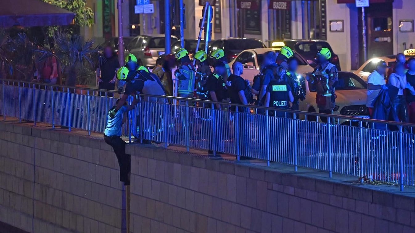 Der Polizist wird von weiteren Rettungskräften aus der Spree geholt: Rechts im Bild ist die Frau zu sehen. Der Polizist wird von weiteren Rettungskräften aus der Spree geholt: Rechts im Bild ist die Frau zu sehen.
